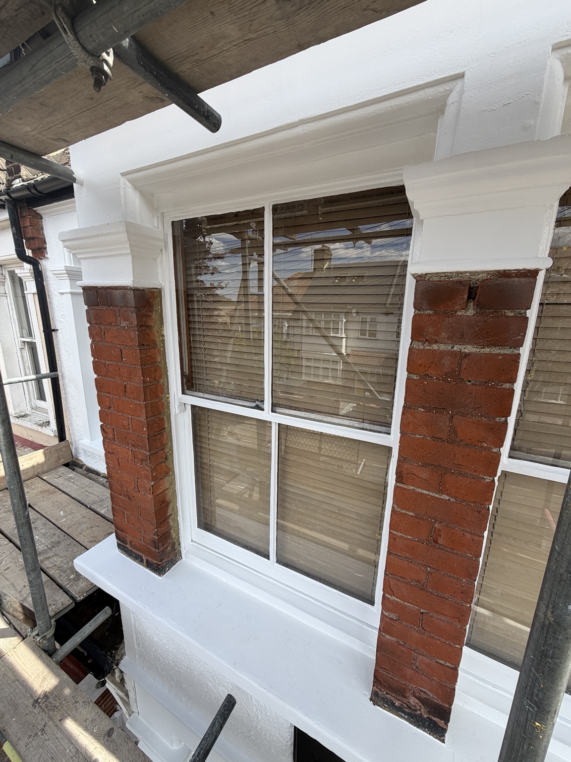 Freshly painted white window surround against red brickwork